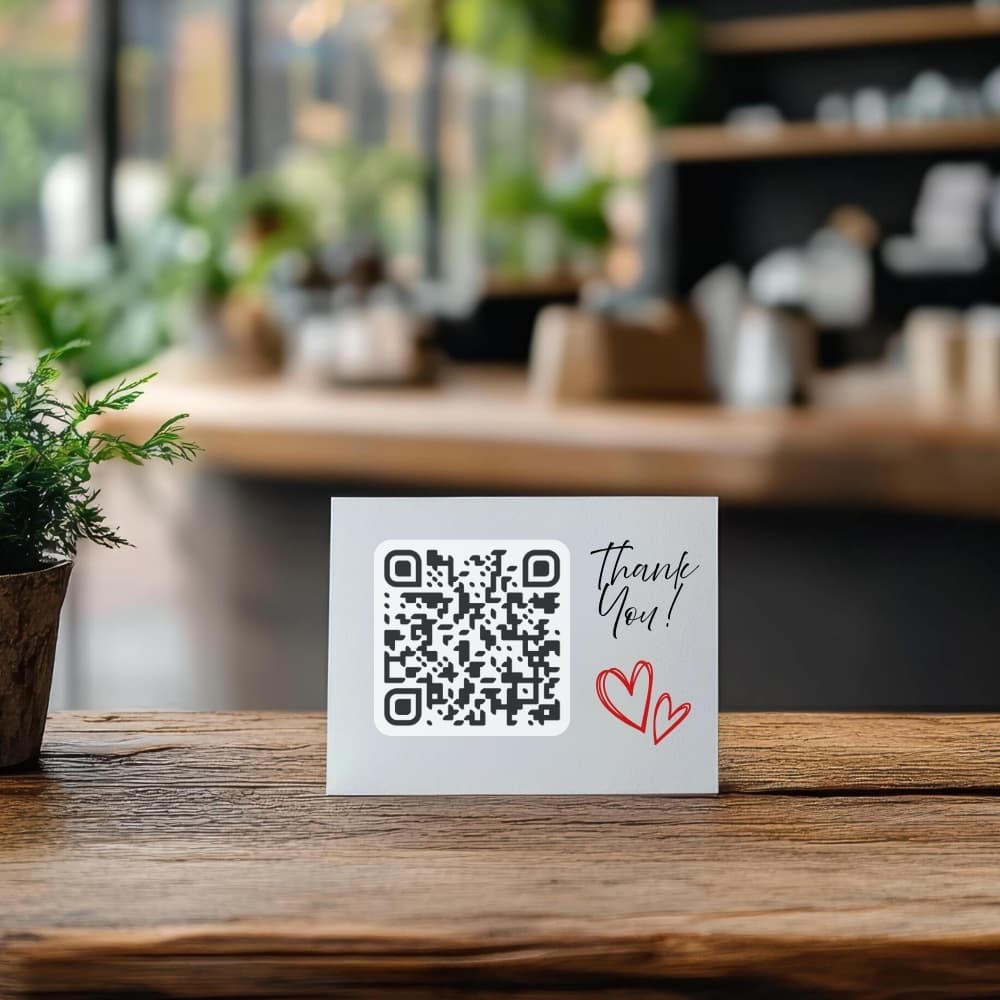 Thank-you card with a TipMe QR code standing on a cafe table