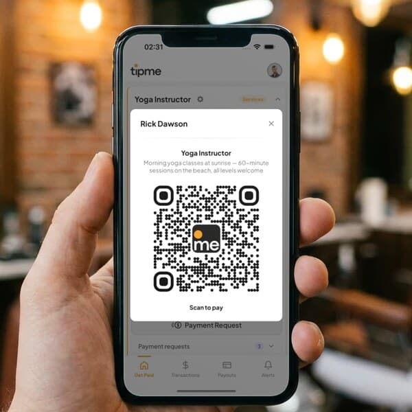 Hand holding a phone that shows a tipme QR code, in a barbershop